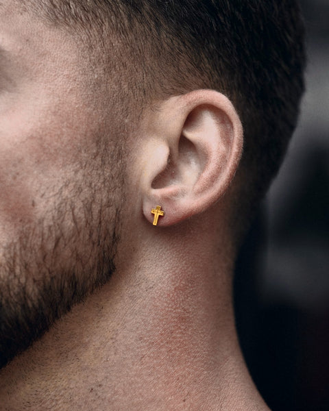 Crux cross stud earring in 24K gold vermeil, worn at the ear.