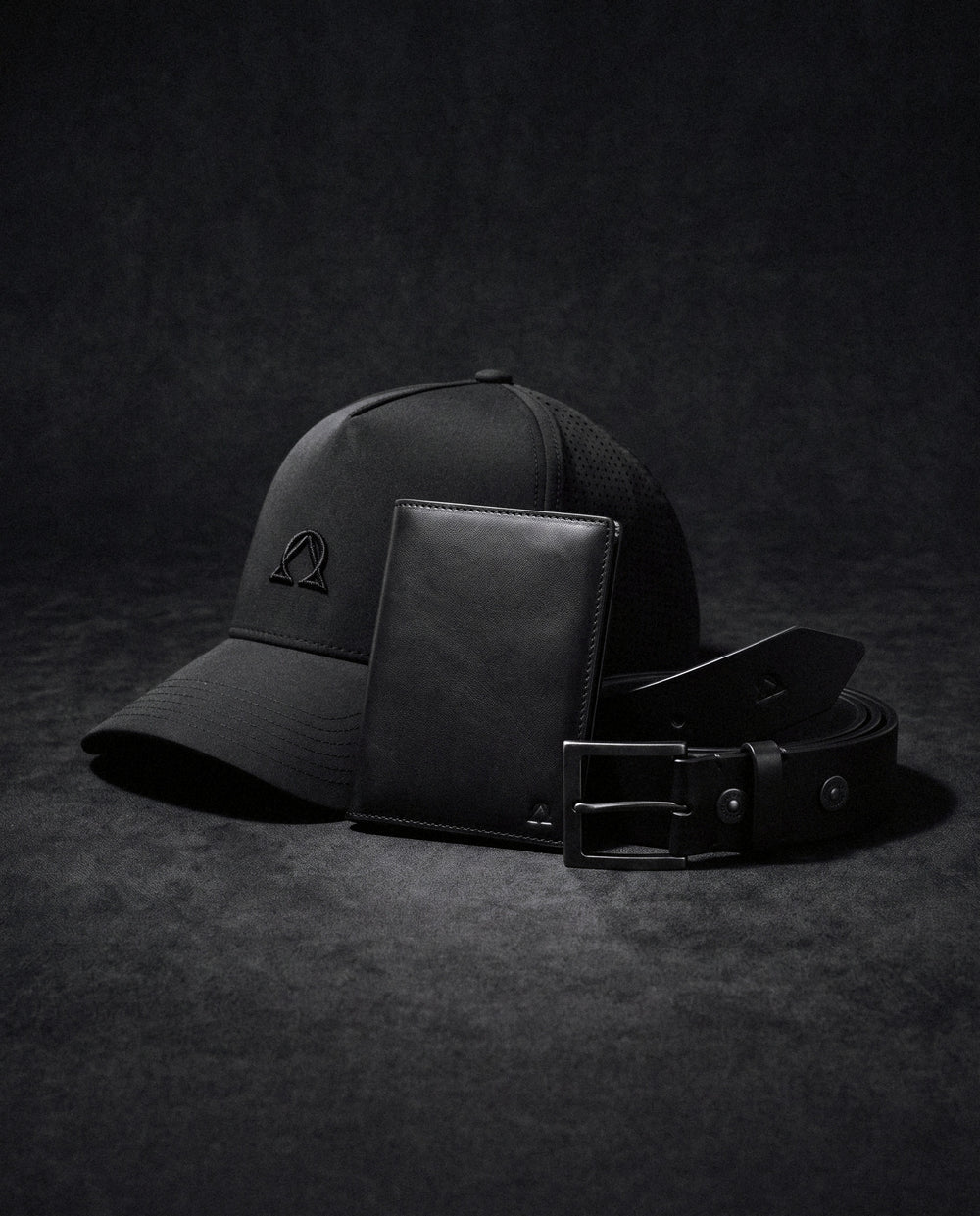 Lux Trucker hat, Virtus Belt, and Atlas Wallet in one colorway on a dark ground, hardware matched.